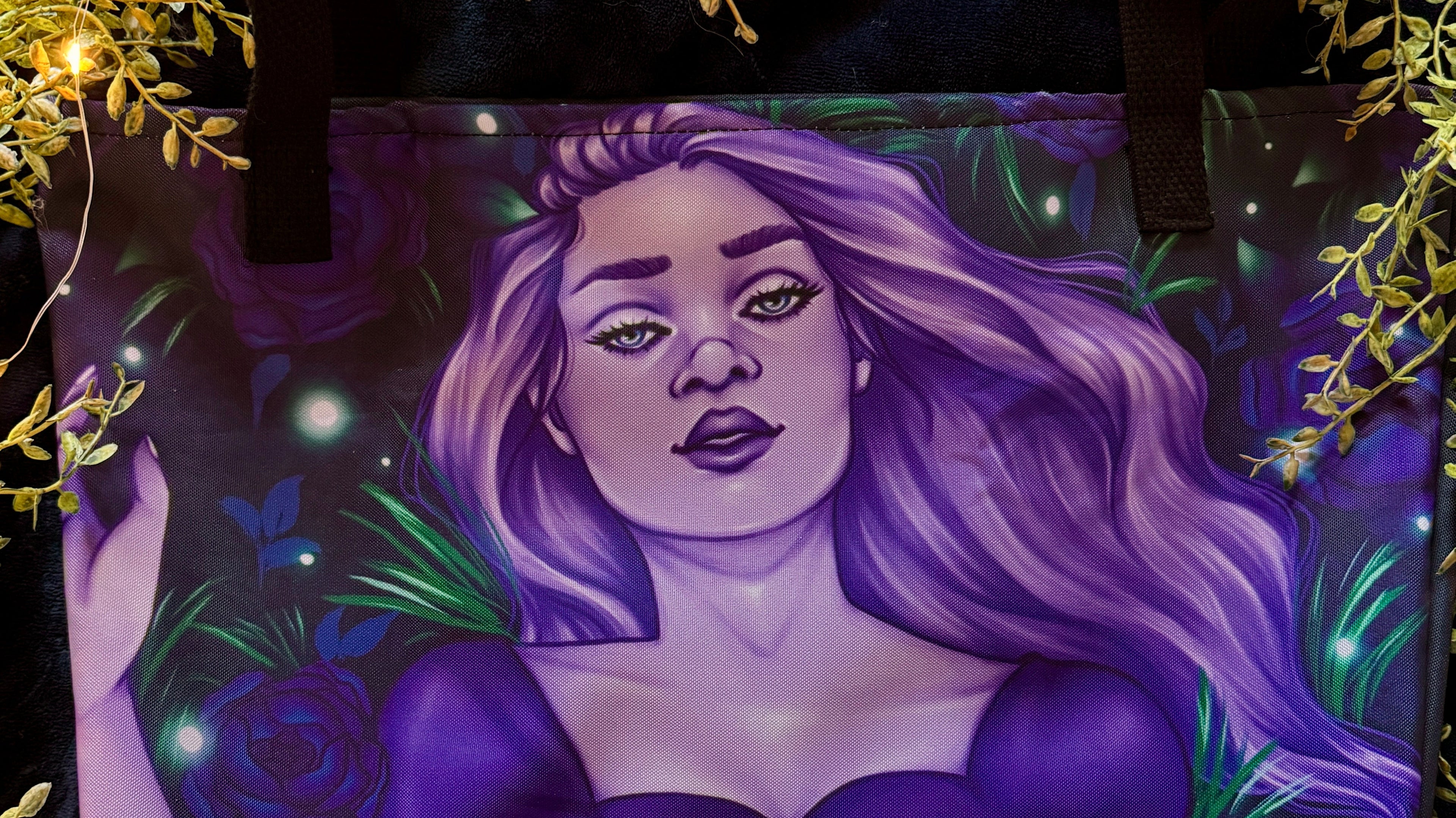Tote bag with a purple-themed design of a woman with long hair, surrounded by foliage and stars.