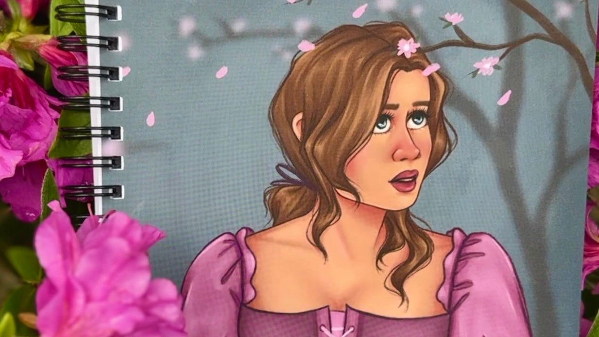 Notebook with a illustration of a woman in a purple dress surrounded by pink flowers